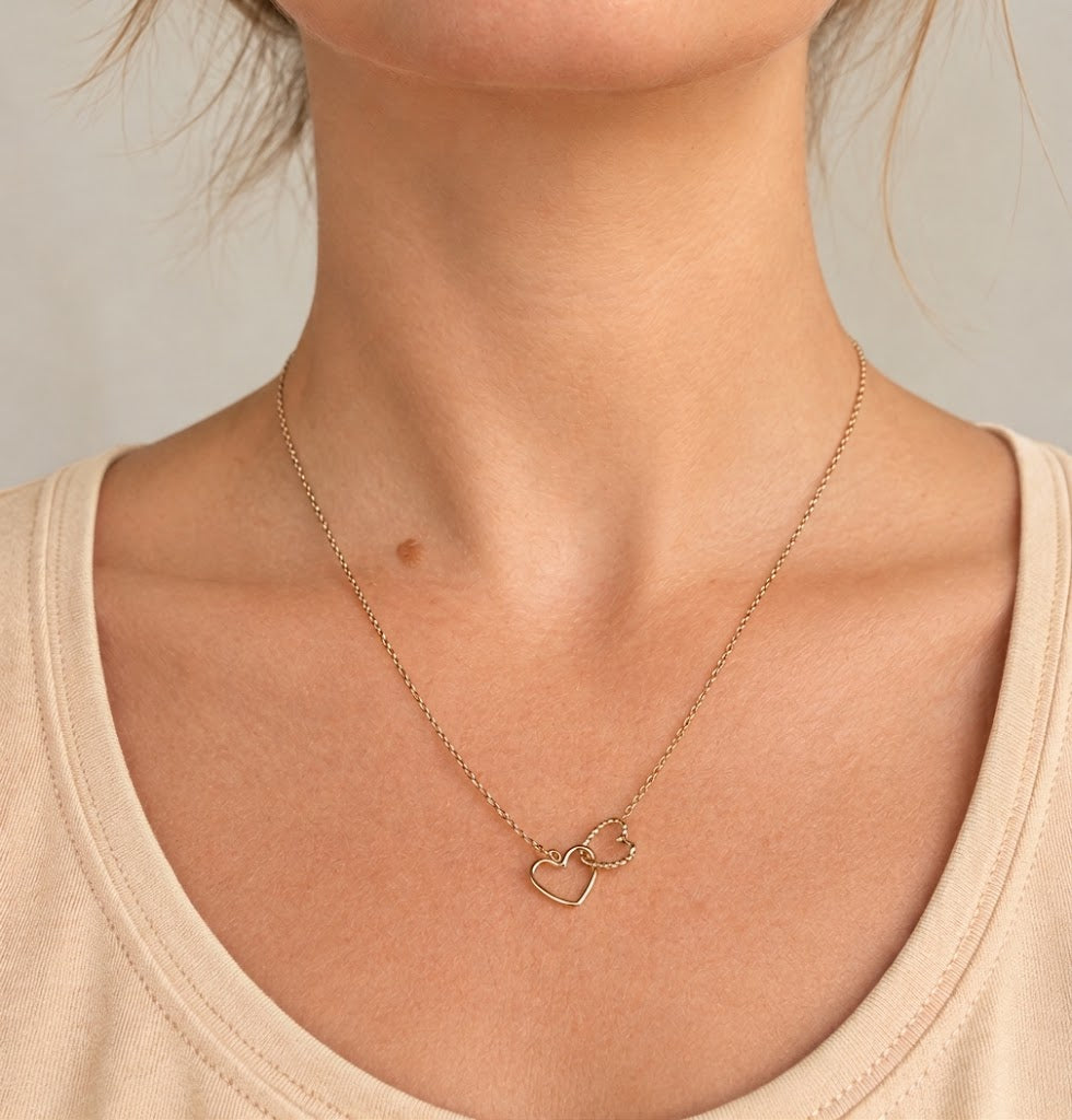Dame draagt ketting met dubbel hartje in warm goud